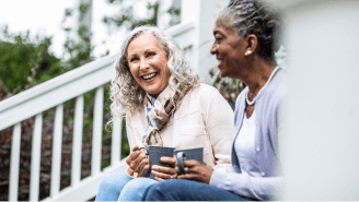 Two happy women enjoying coffee together