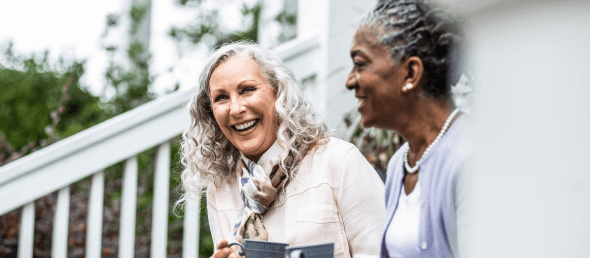 Two happy women enjoying coffee together